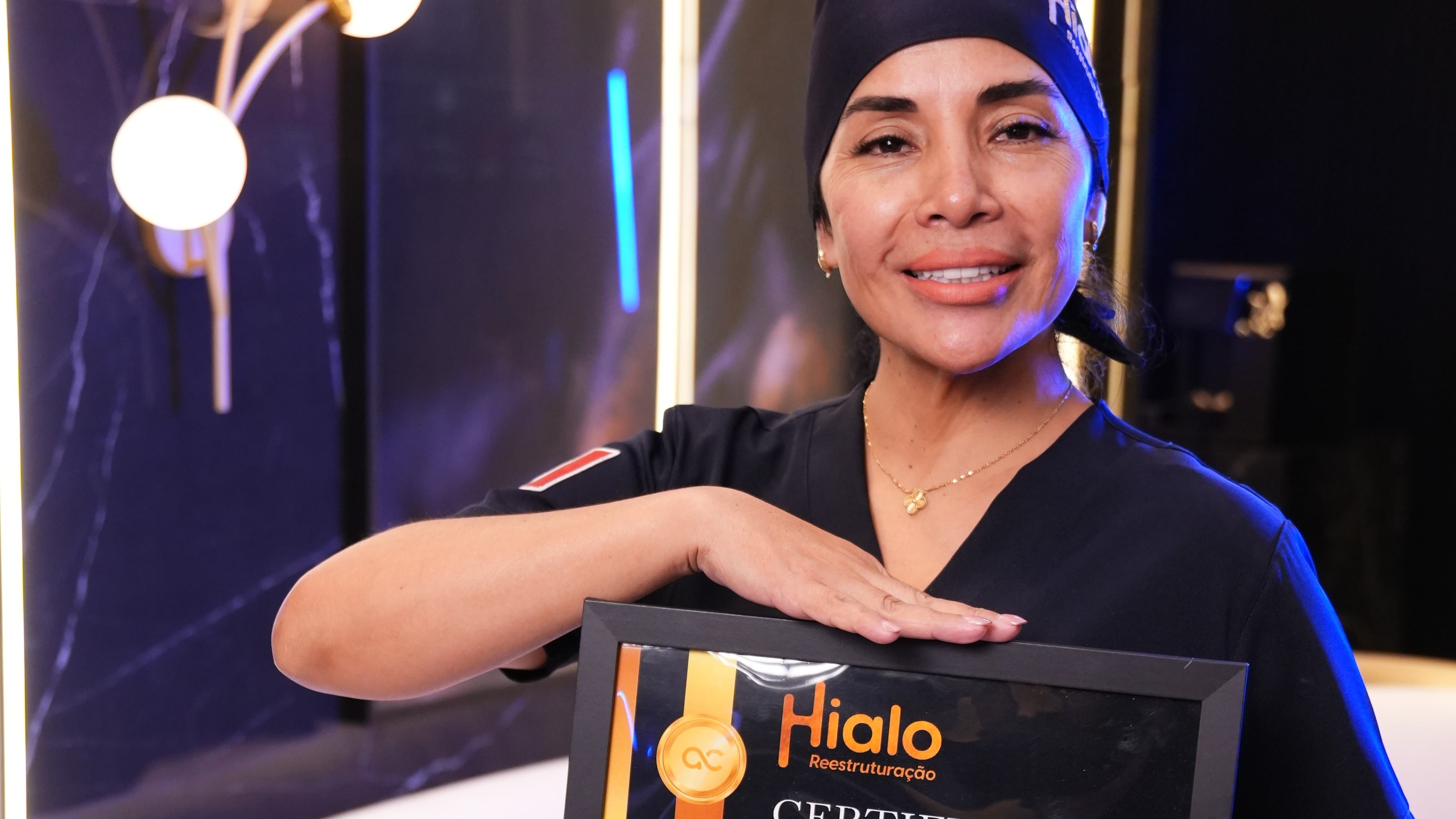 Aluna da formação Hialo com o certificado em mãos